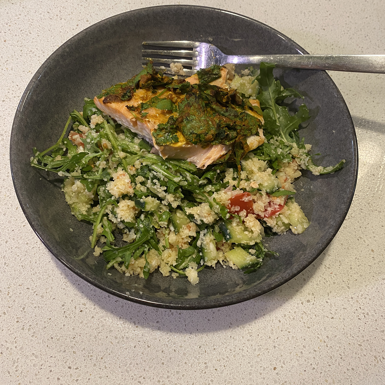 salmon filled with herb crust and cauliflower rice salad with tomato and roquette