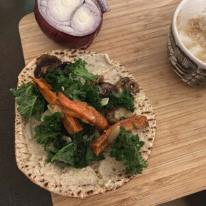 nutrition essentials for mental health - the makings of a veggie sausage pita sandwich with leftover kale salad and tahini sauce