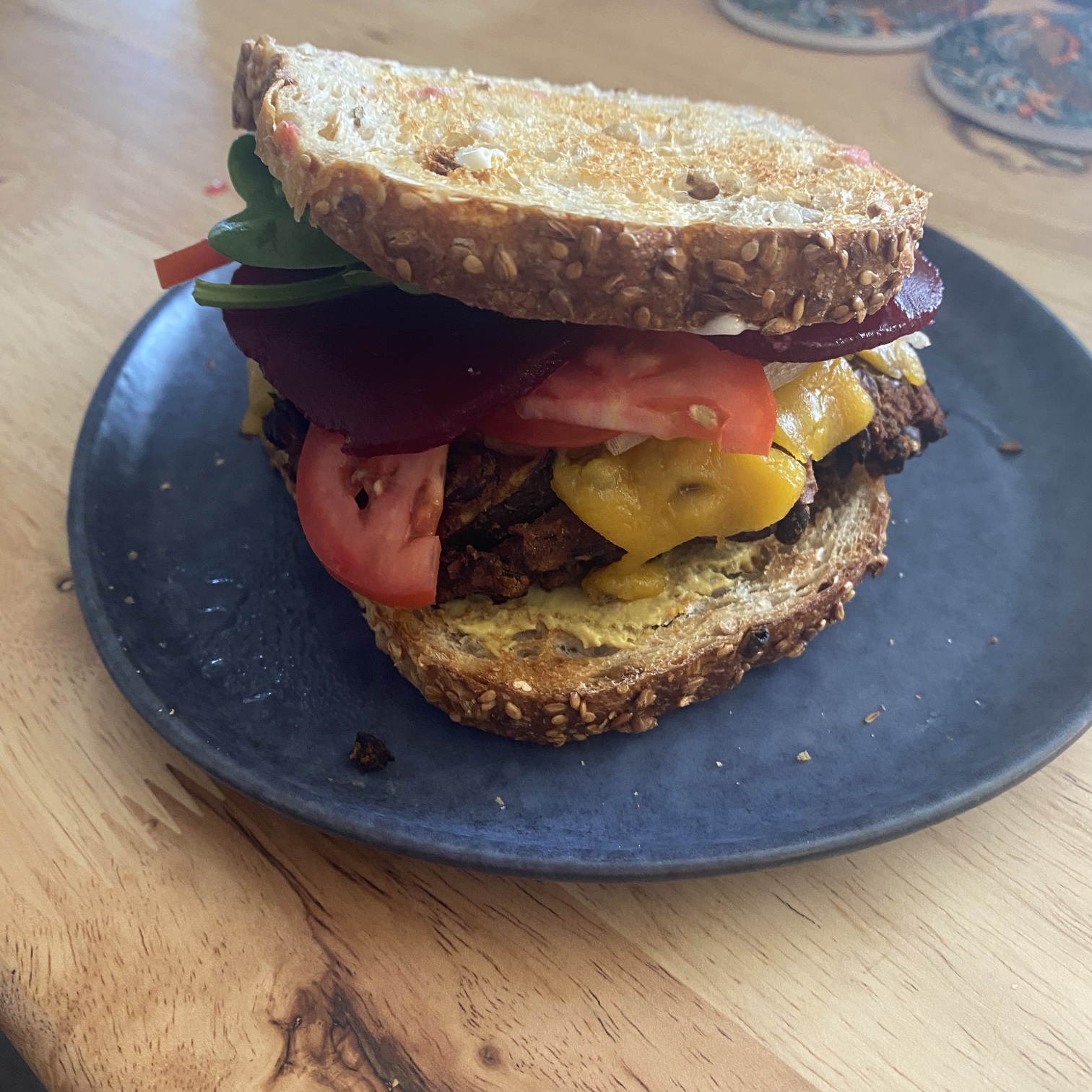 lentil veggie burger recipe - a burger with all the ingredients! Can see tomato, beetroot and the burger patty