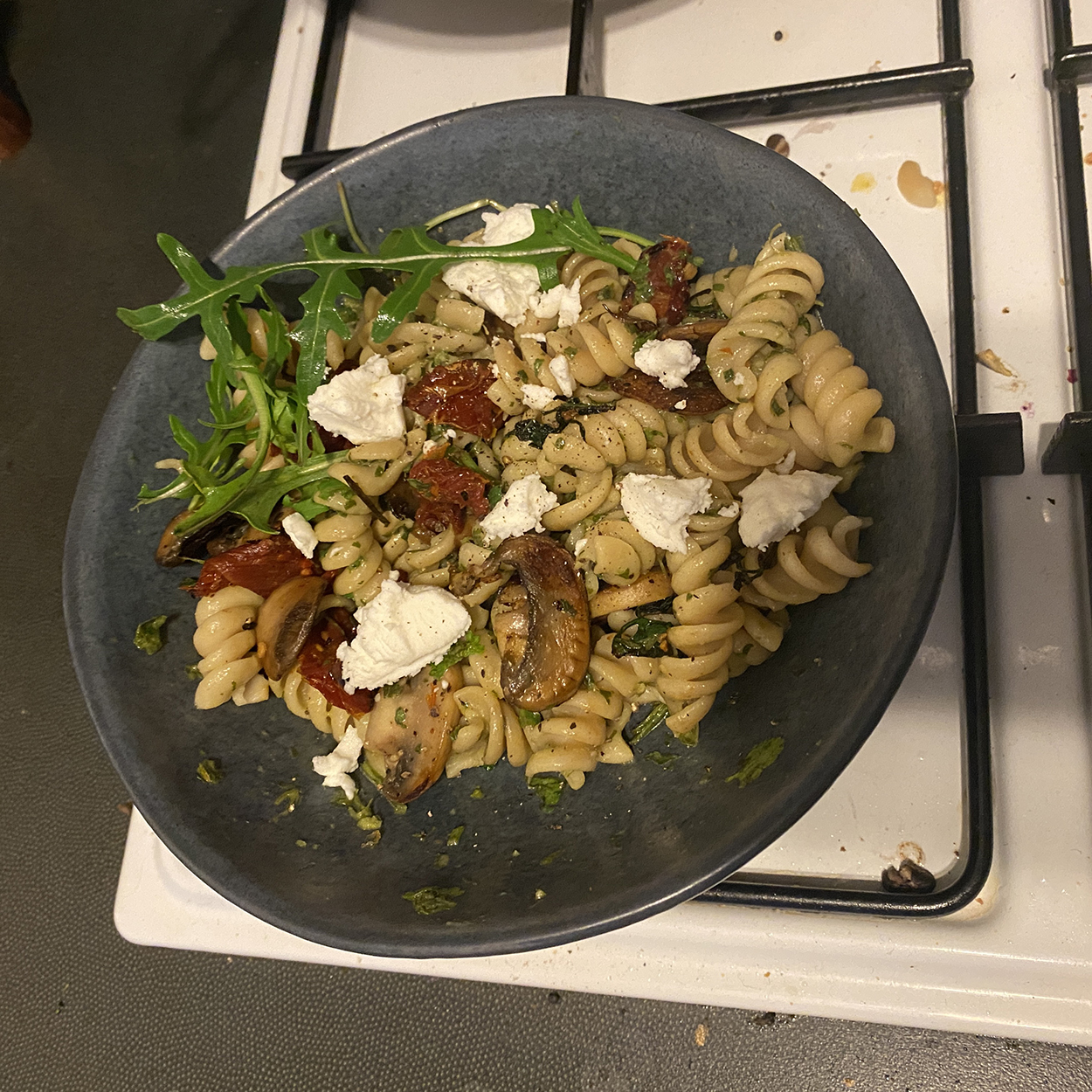 what's cooking? pesto pasta with mushrooms, sun dried tomatoes, goats cheese, and roquette