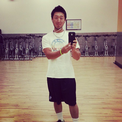 man standing at gym taking selfie - extrinsic motivation for health and fitness motivation