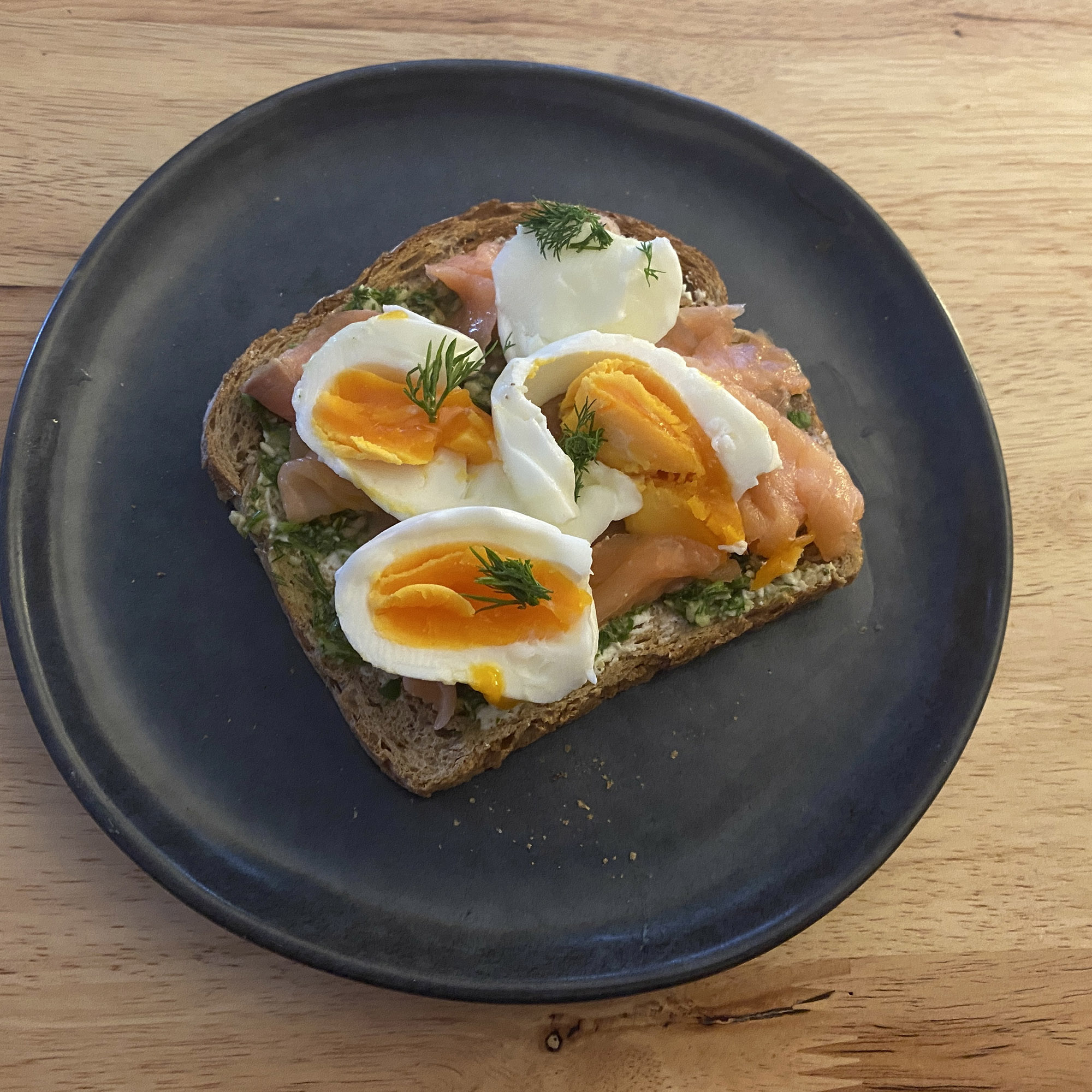pesto toast recipe - piece of toast with salmon, goat's cheese, pesto and dill - to highlight the high protein breakfast benefits