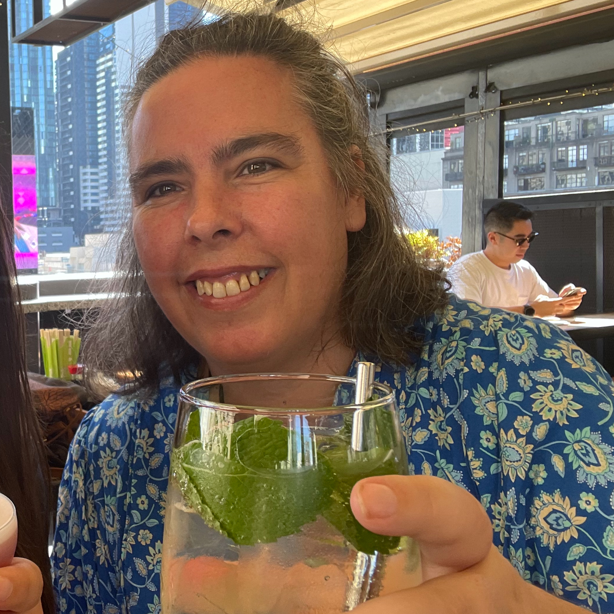 sarah james - my health zest meal preparation and planning - sarah is smiling at the camera and cheersing with her glass of mineral water