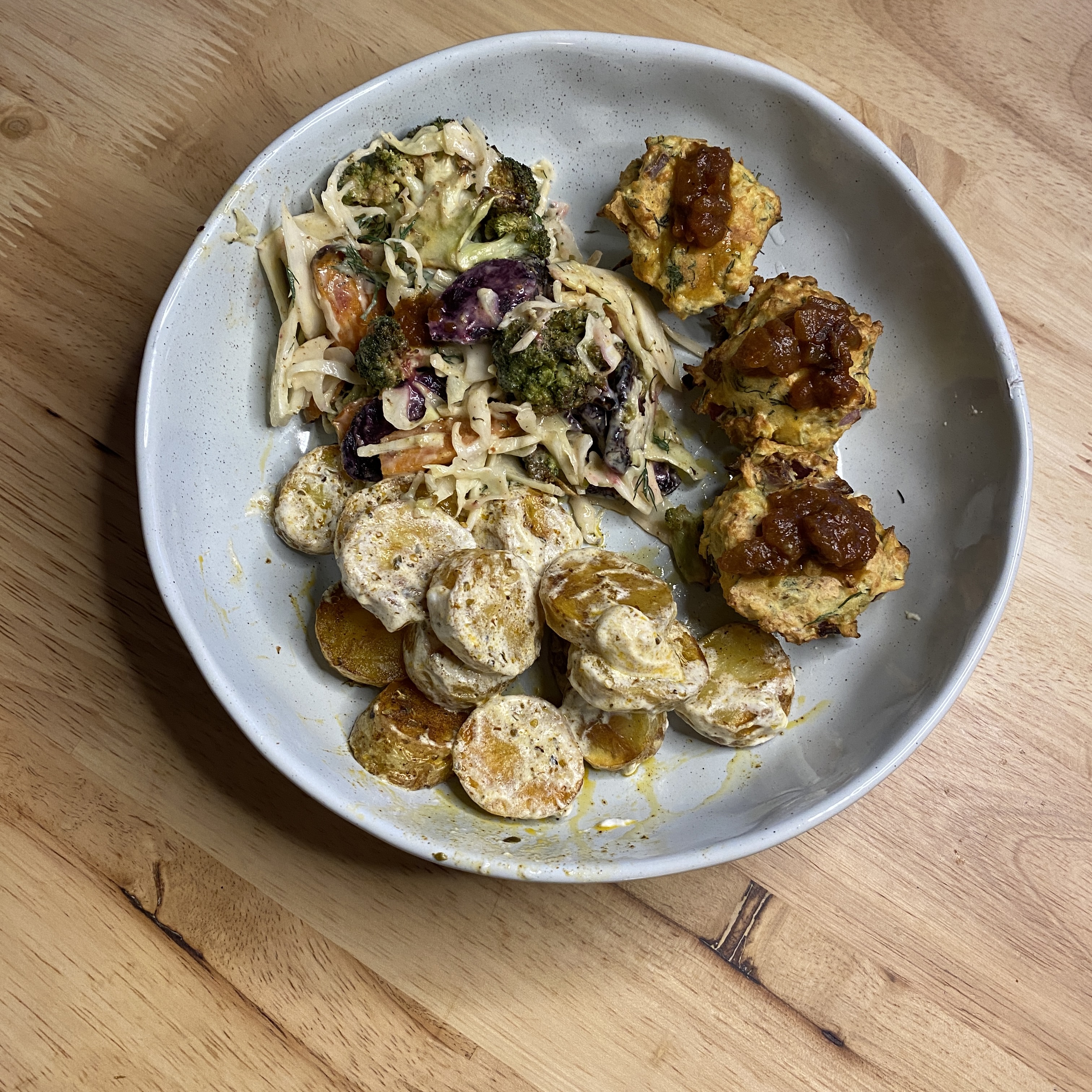 dinner bowl with tempeh bites and tomato chutney, roasted paprika and oregano potates in yoghurt dressing, and roasted heirloom carrot and broccoli slaw