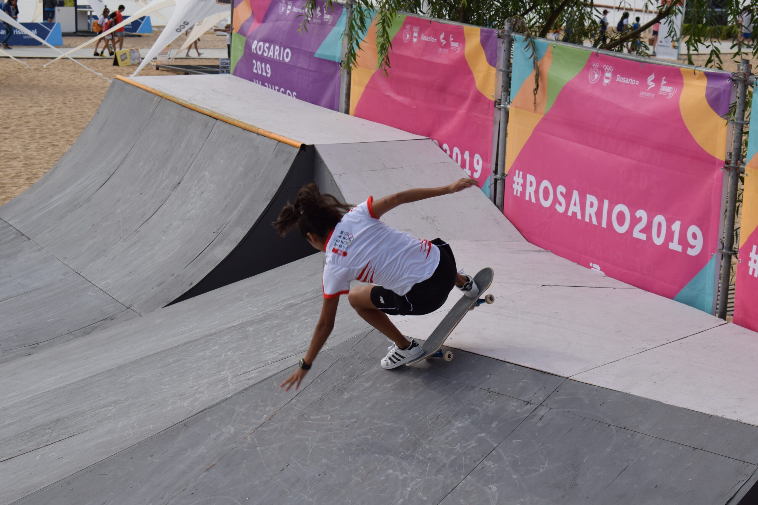 woman doing a trick at a skate park competition