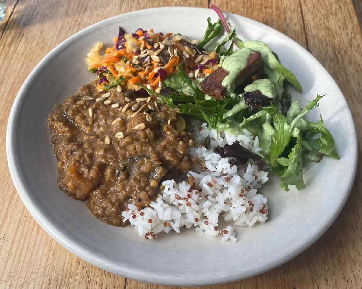 FoE lunch bowl with lentil curry, salad and zesty baked tempeh