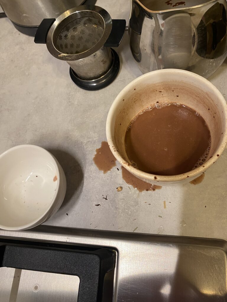second helpings - what is LEFT of the chocolate - a half filled cup and some sprinklings of hot chocolate around