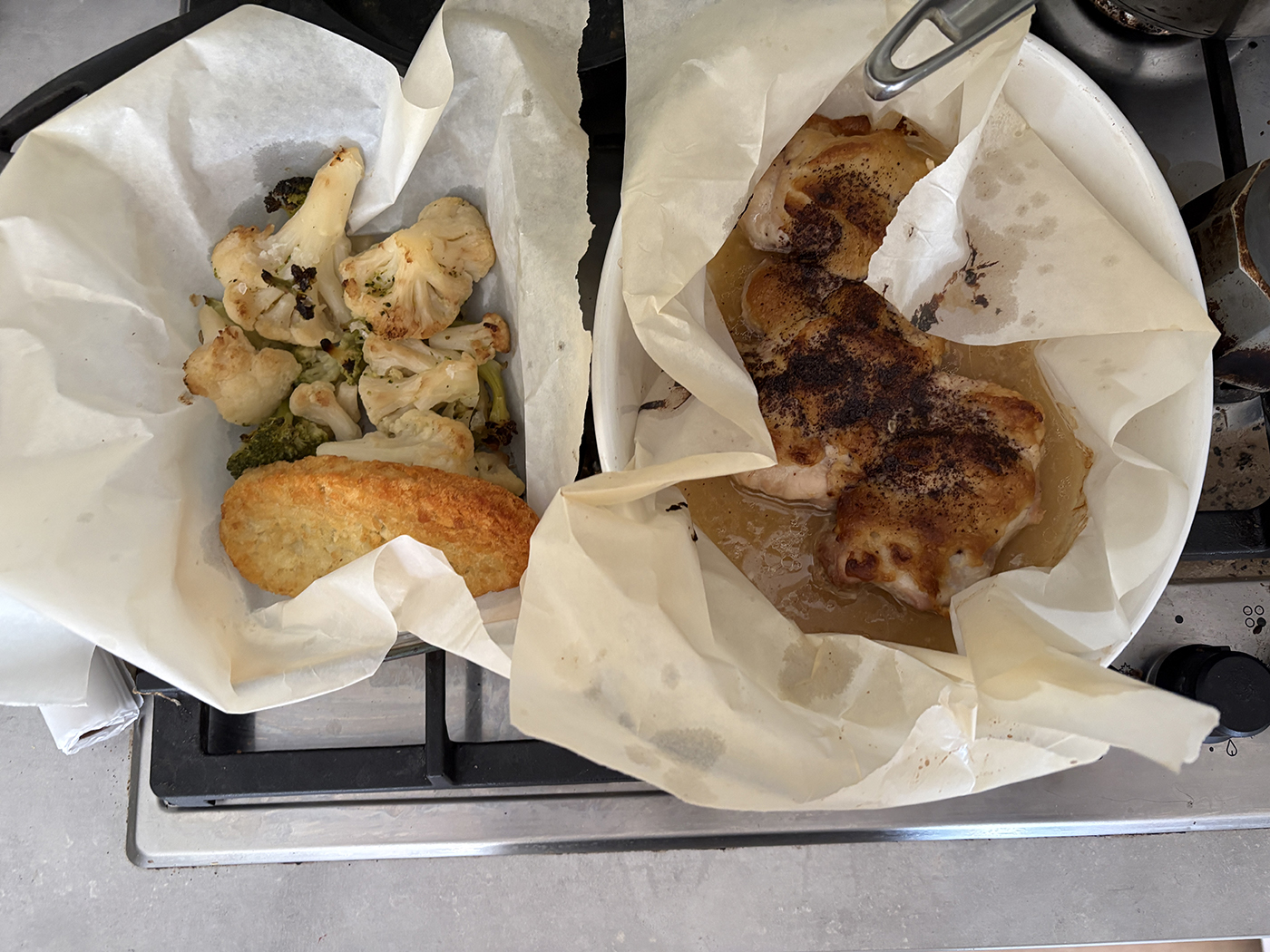 two baking dishes lined with baking powder and chicken with hummus crust and baked veggies and a hash brown for good measure