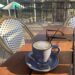 blue coffee cup on wooden table with view of river - which is the healthiest plant milk?